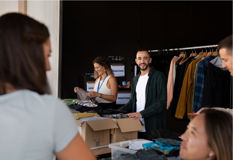 A group of people are sorting through boxes of clothes