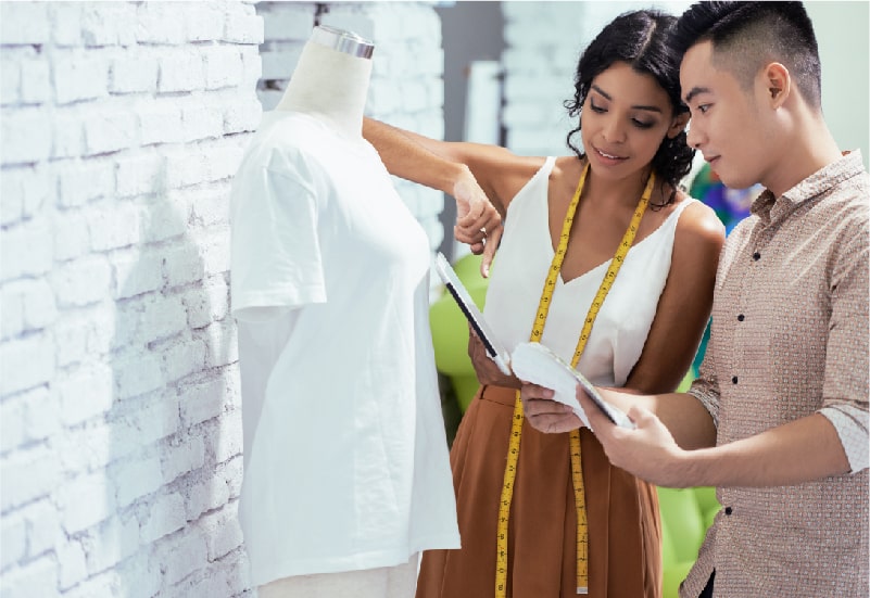 A man and woman are testing quality for a sample t-shirt