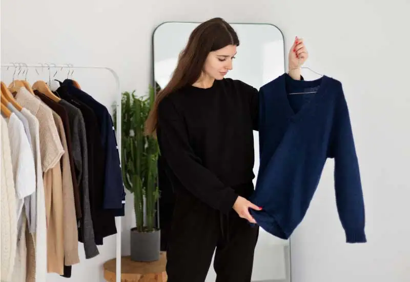 Woman is looking for a sweater in a clothing store