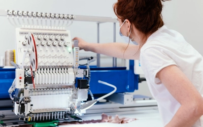 A woman is using an embroidery machine