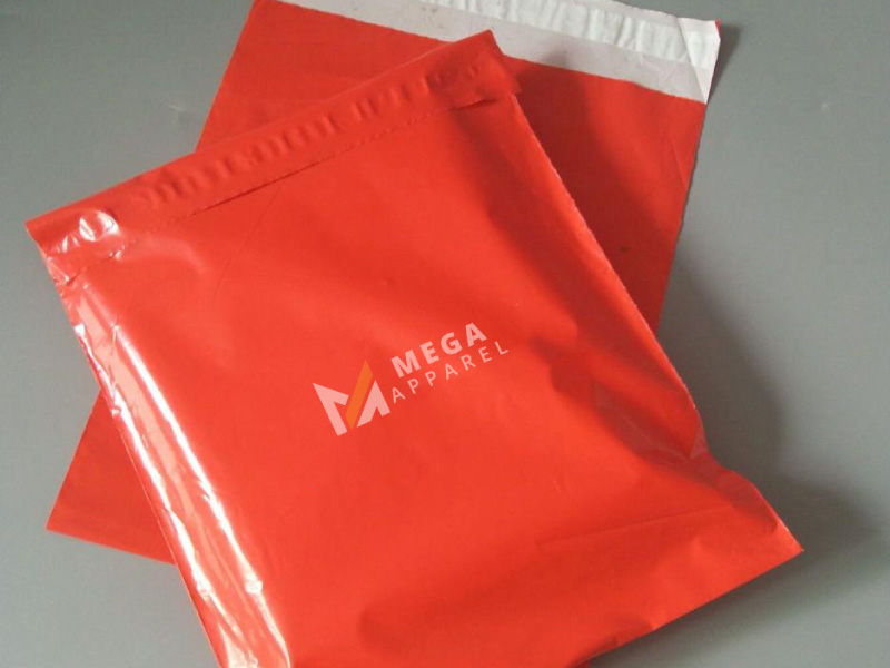 Two bright red plastic bags with the Mega Apparel logo
